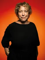 Tanja Sagasser-Beil, Halbportrait, lächelnd, Blick in Kamera, roter Hintergrund