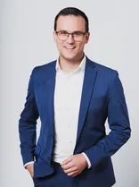 Dr. Tim Breitkreuz, formelles Halbporträt, lächelnd, Blick in Kamera, neutraler Hintergrund