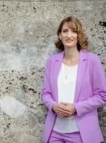 Isabell Huber, formelles Halbporträt, lächelnd, Blick in Kamera, draußen