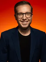 Christian Holzer Halbportrait, lächelnd, Blick in Kamera, roter Hintergrund