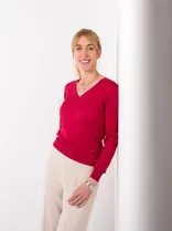 Cornelia von Loga, Halbportrait, lächelnd, Blick in Kamera, neutraler Hintergrund