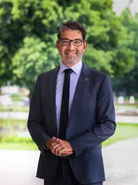 Andre Baumann, Halbportrait, lächelnd, Blick in Kamera, draußen