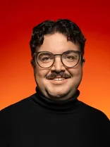 Can Kurter, Portrait, lächelnd, Blick in Kamera, roter Hintergrund