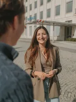 Giuliana Ioannidis, Halbportrait, lächelnd, Blick in Kamera, gehend, draußen