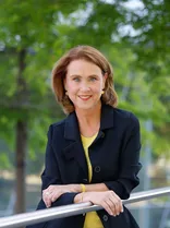 Petra Olschowski, Halbporträt, lächelnd, Blick in Kamera, draußen