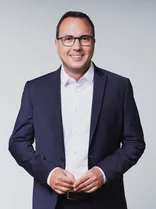 Andreas Deuschle, formelles Halbporträt, lächelnd, Blick in Kamera, neutraler Hintergrund