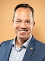 Nicolas Fink, •	formelles Porträt, Blick in Kamera, gelber Hintergrund