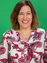 Maren Seifert, Halbportrait, lächelnd, Blick in Kamera, grüner Hintegrund