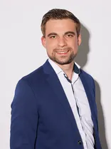 Veit Grünberg, Halbportrait, lächelnd, Blick in Kamera, neutraler Hintergrund