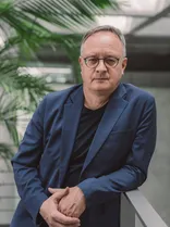 Andreas Stoch, Halbportrait, lächelnd, Blick in Kamera, neutraler Hintergrund