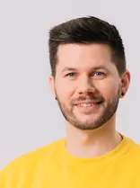 Pascal Haggenmüller, Halbportrait, lächelnd, Blick in Kamera, neutraler Hintergrund