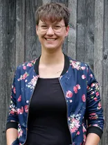 Lea Geldner, formelles Halbporträt, lächelnd, Blick in Kamera, draußen