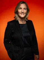 Bettina Ahrens-Diez, Halbportrait, lächelnd, Blick in Kamera, roter Hintergrund