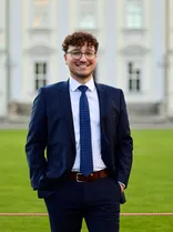 M. Berat Gürbüz, formelles Halbporträt, lächelnd, Blick in Kamera, draußen