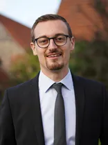 Tim Reeth, formelles Halbporträt, lächelnd, Blick in Kamera, draußen