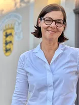 Sibylle Riegger-Gnamm, formelles Halbporträt, lächelnd, Blick in Kamera, draußen