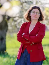 Simone Kirschbaum, formelles Halbporträt, lächelnd, Blick in Kamera, draußen