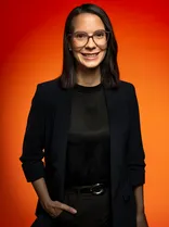 Annkathrin Wulff, Halbportrait, lächelnd, Blick in Kamera, roter Hintergrund