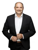 Stefan Teufel, formelles Halbporträt, lächelnd, Blick in Kamera, neutraler Hintergrund