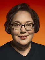 Beate Essafi, Portrait, lächelnd, Blick in Kamera, roter Hintergrund