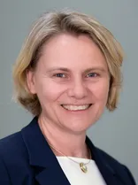 Christiane Staab, Portrait, lächelnd, Blick in Kamera, neutraler Hintergrund