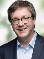 Dr. Michael Preusch, formelles Porträt, lächelnd, Blick in Kamera, neutraler Hintergrund