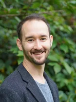 Jens Metzger, Halbportrait, lächelnd, Blick in Kamera, draußen