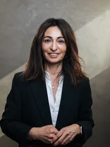 Sengül Engelhorn, Halbportrait, lächelnd, Blick in Kamera, neutraler Hintergrund