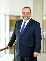 Christian Jung, Halbportrait, lächelnd, Blick in Kamera, neutraler Hintergrund