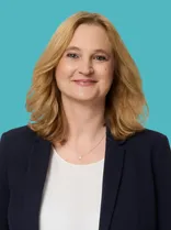 Regina Dvorak-Vucetic, formelles Porträt, Blick in Kamera, blauer Hintergrund