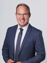 Raimund Haser, formelles Halbporträt, lächelnd, Blick in Kamera