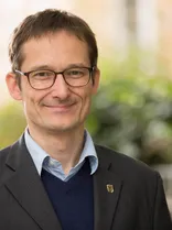 Hermino Katzenstein, Halbportrait, lächelnd, Blick in Kamera, draußen