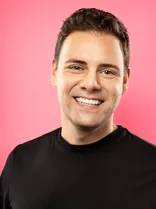 Florian Wahl, formelles Portrait, lächelnd, Blick in Kamera, roter Hintergrund