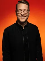 Paul Frank, Portrait, lächelnd, Blick in Kamera, roter Hintergrund