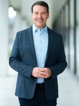 Oliver Hildenbrand, formelles Halbporträt, lächelnd, Blick in Kamera, draußen