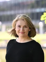 Claudia Schober, lächelnd, Blick in Kamera, draußen